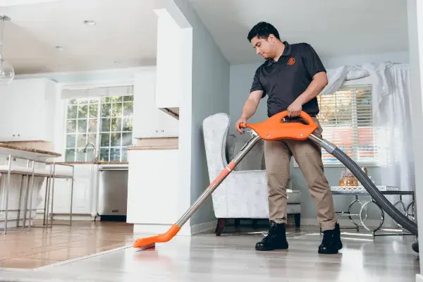 Technician extracting standing water from a Cary floor